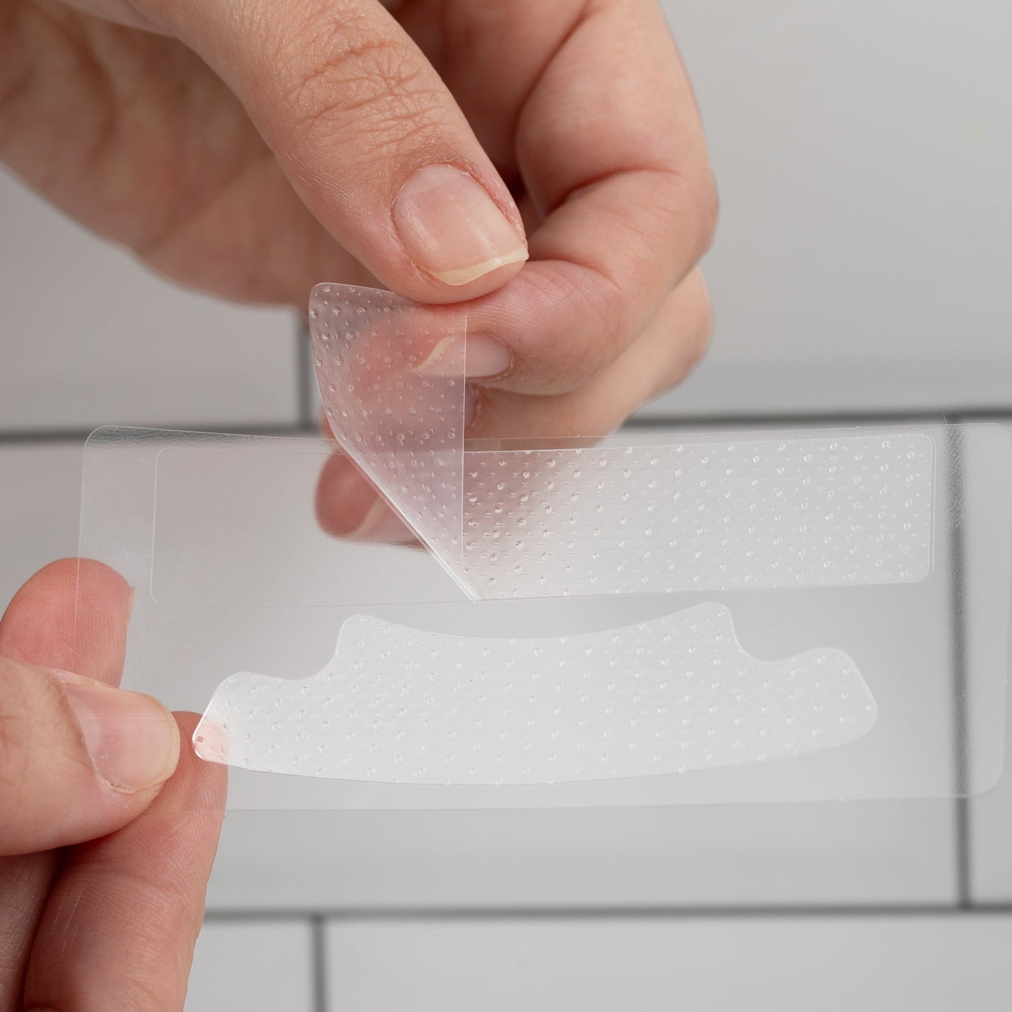 Close-up of nanoWHITE non-slip whitening strip being peeled from backing for application