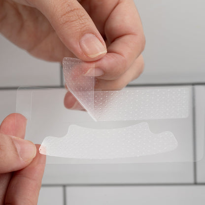 Close-up of nanoWHITE non-slip whitening strip being peeled from backing for application